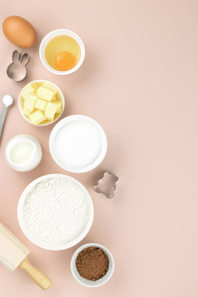 istock Baking ingredients and tools - flour, sugar, butter, eggs, cocoa, milk, baking powder, rolling pin, whisk, cookie cutters. Top view, copy space. Ingredients for cake, cookies, muffins. 1406631290