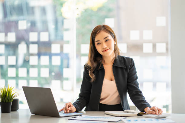 istock Asian businesswoman working using laptop computer in modern office Make an account analysis report with financial graphs and real estate investment data. financial and tax system concepts 1406632117