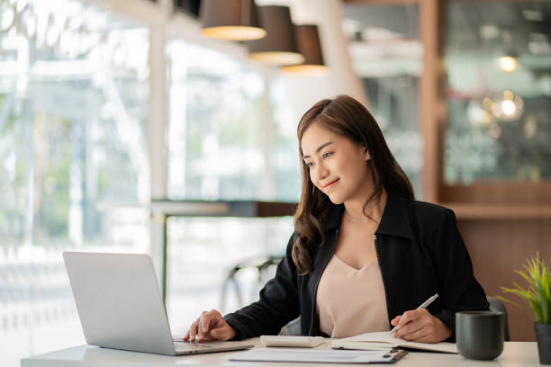 istock Asian businesswoman working using laptop computer in modern office Make an account analysis report with financial graphs and real estate investment data. financial and tax system concepts 1406632141