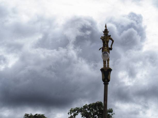 Kinnaree lamppost and turquoise sky with gray and white clouds in the background.
