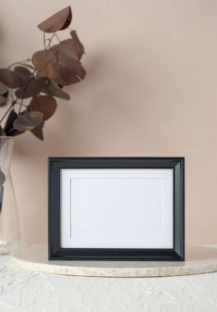 istock blank black photo frame mockup with eucalyptus brancch at peach wall 1406633044