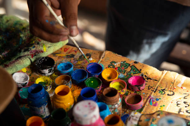 istock Man's hand dipping paintbrush with paint 1406634963