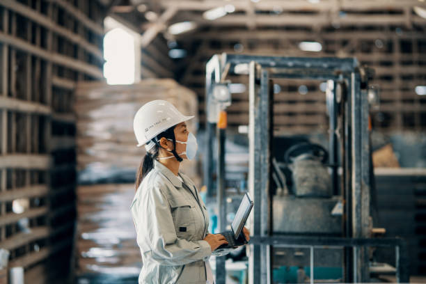 倉庫でデジタルタブレットを使用する中年成人女性 - freight transportation warehouse manufacturing shipping ストックフォトと画像