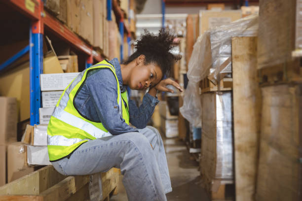 Tired stress woman worker labor working in warehouse cargo inventory industry. stock photo