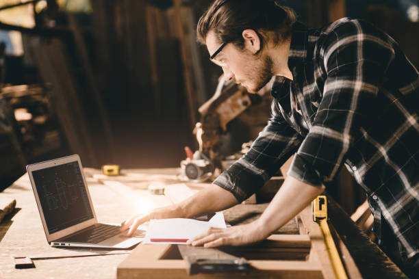 istock builder wood worker wooden furniture maker using laptop computer to design project 1406639208