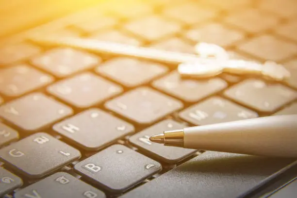 Photo of The pen is mightier than the sword concept : Ballpoint pen and a sword on a laptop. This proverb or phrase is a metonymic adage, indicating that a journalist can report lie or truth using only a pen.