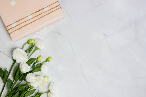 istock White roses bouquet with pink gift box over the marble background with copy space. 1406643966
