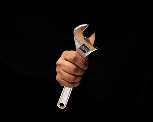 istock Asian male dark skinned single hand fist finger on black background holding using adjustable wrench 1406644059
