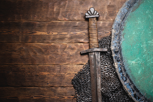 Medieval concept flat lay background. Sword and shield background with copy space.