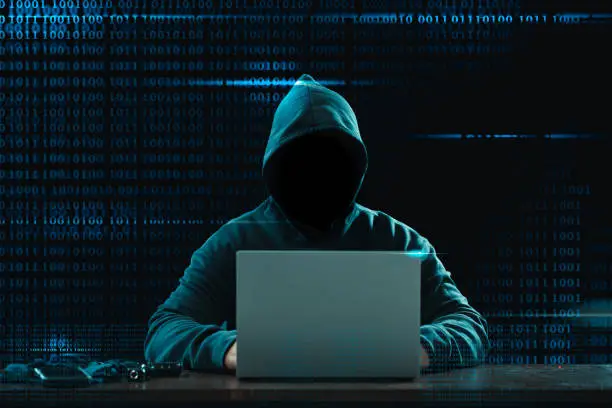 Big financial data theft concept. An anonymous hacker is hacking highly-protected financial data through computers.