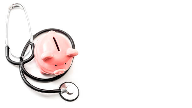 healthcare cost and the high price of quality health care insurance concept theme with a stethoscope and a pink piggy bank isolated on white background with copy space - currency stethoscope medicare usa imagens e fotografias de stock