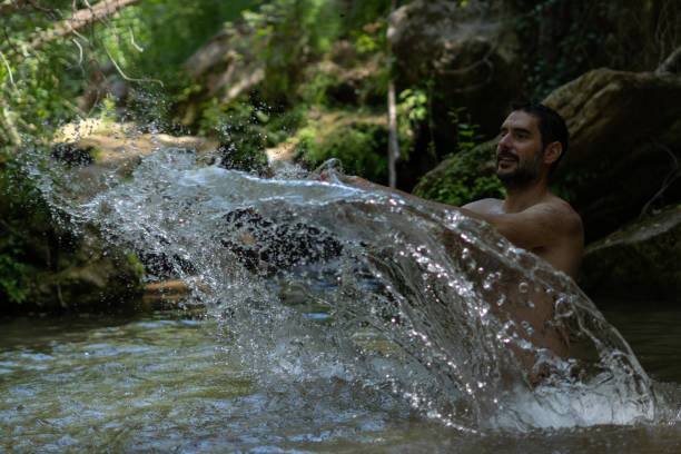 istock man in the river splashing water with his hands 1406654293