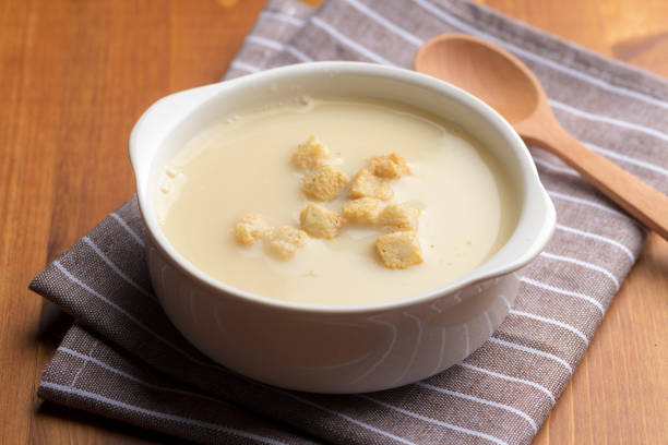 Drink warm corn soup with a wooden spoon.