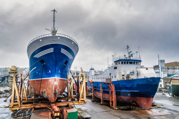 Small shipyard, ships being repaired and crane.  Ribeira, Barbanza, A Coruña province, Galicia, Spain.