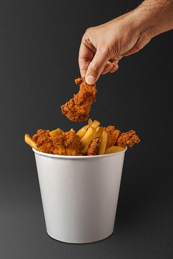 Man holding fried chicken in bucket