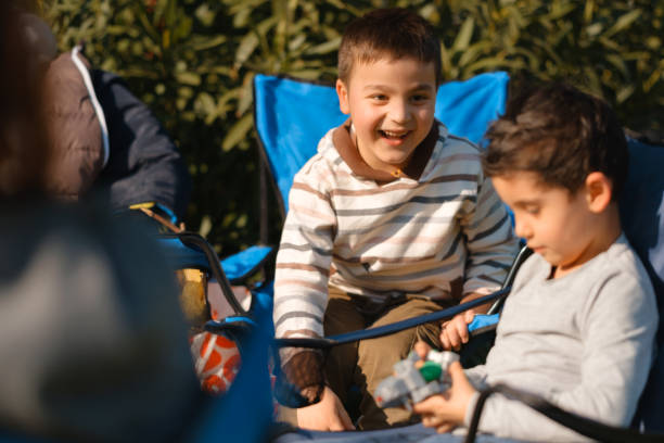 istock Two boys playing sitting in a camping chair 1406657531