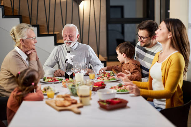 istock Happy extended family talking during lunch in dining room. 1406661036