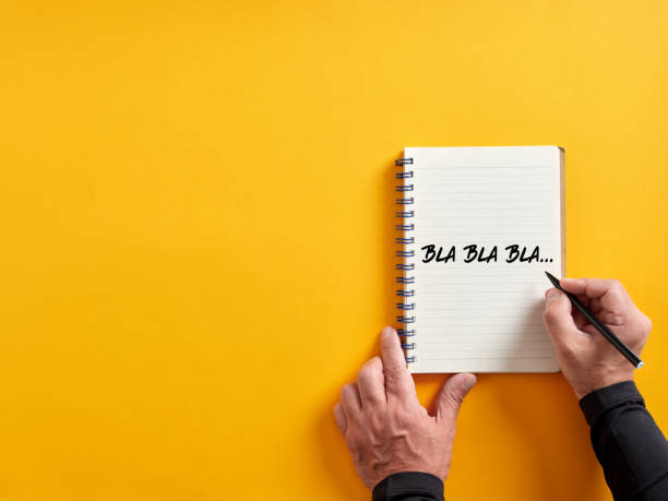 istock Male hand writing bla bla bla on a notepad. Business concept for talking too much with false information or gossip nonsense speaking. 1406661092