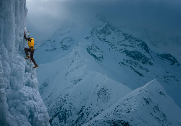 starker mann erklimmt vertikale eiswand - risk mountain climbing climbing conquering adversity stock-fotos und bilder