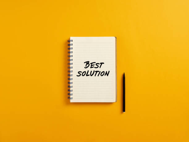 istock Notepad and black pen on yellow background with the word best solution for business 1406663991