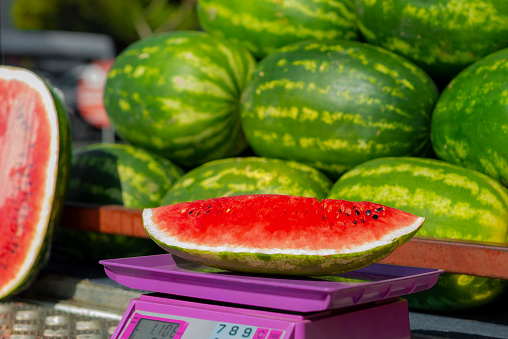 A slice of watermelon, whose weight is measured on the scale. Buying slices of watermelon from the grocery store due to the cost of living. Turkey