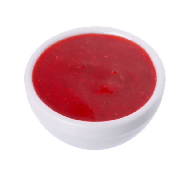 istock Strawberry jam in white ceramic bowl, isolated on white background. Red berry confiture. 1406668276