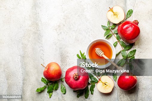 istock Rosh hashanah, greeting card with symbols of Jewish New Year holiday pomegranate, honey and apples. Traditional symbols on light stone background. Copy space. 1406668449