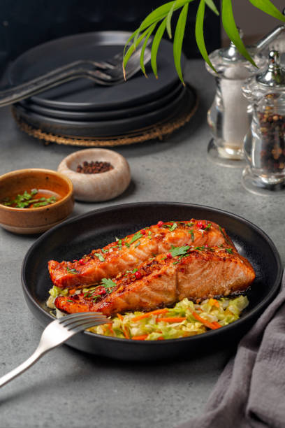 istock Honey garlic glazed salmon with cabbage, carrot bell pepper slaw. Vertical image. 1406668452