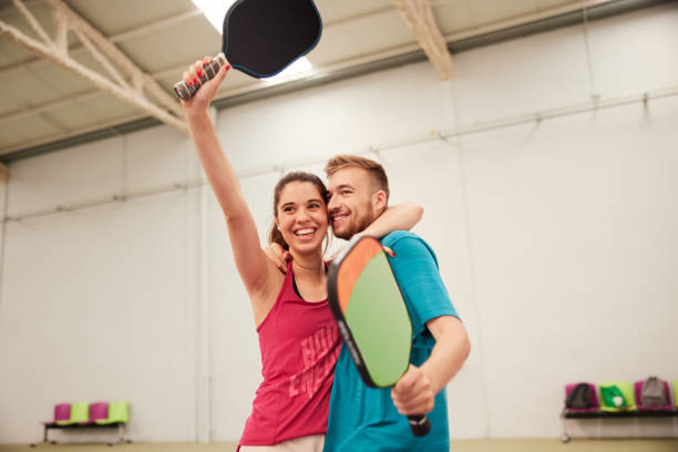 Two friends celebrate scoring a point in a pickleball match.