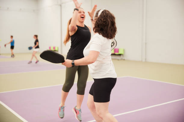 istock Two middle-aged women celebrate winning a point. 1406673659
