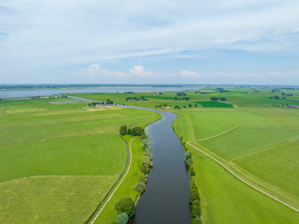 сельский пейзаж с рекой через луга, видимые сверху - polder стоковые фото и изображения