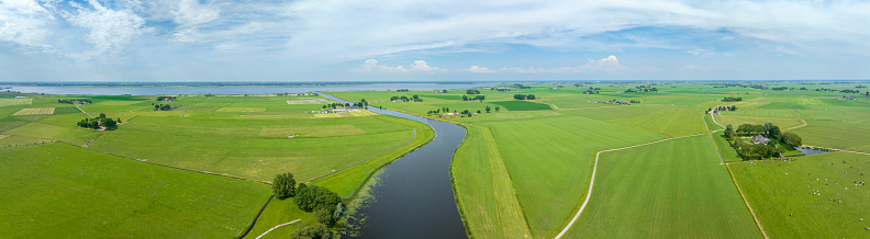 Green meadows at Kampereiland with the Genzendiep river running towards the Zwarte Meer in the IJsseldelta region in The Netherlands.