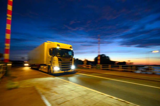 istock Truck driving at night over a bridge 1406675880