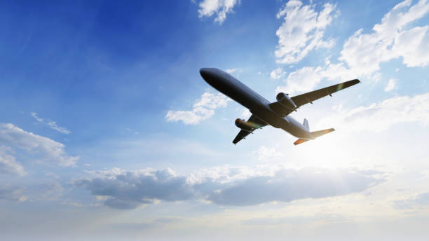 青い空を背景に太陽の光が降り注ぐ空中を飛ぶ飛行機。旅行の旅とワンダーラストの輸送コンセプト。3dイラストレーションレンダリング - 飛行機 ストックフォトと画像