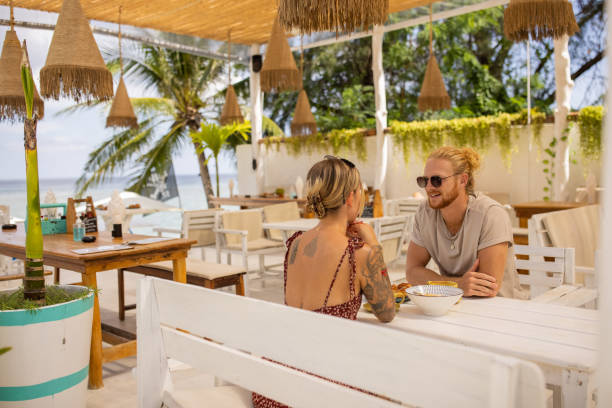istock Young Caucasian couple enjoy breakfast at the beach restaurant 1406677423