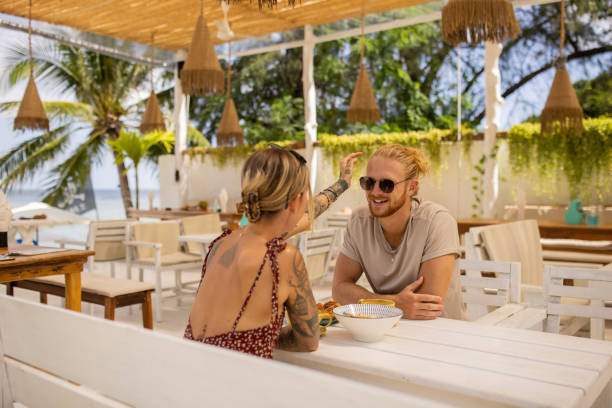 istock Young Caucasian couple enjoy breakfast at the beach restaurant 1406678059