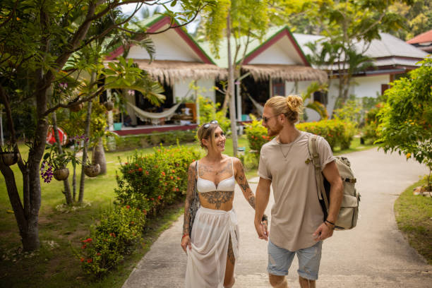 istock Caucasian couple holding hands, while walking through tourist resort 1406678945