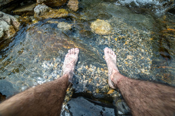 istock Hiker resting his feet in the river. 1406679013