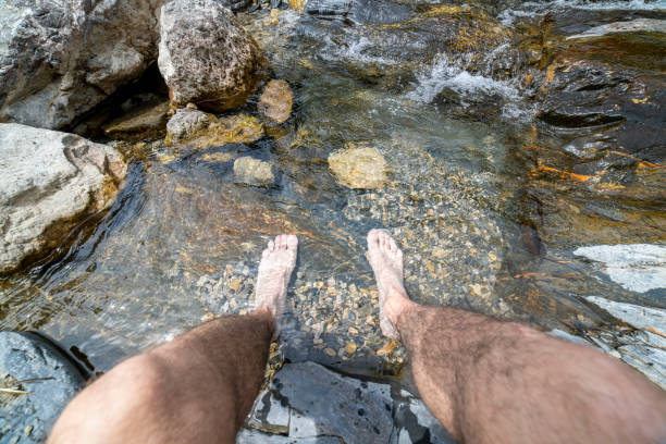 istock Hiker resting his feet in the river. 1406679037