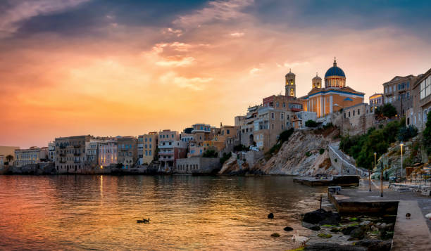 das stadtbild der stadt ermoupolis bei sonnenuntergang - sea aegean sea night illuminated stock-fotos und bilder