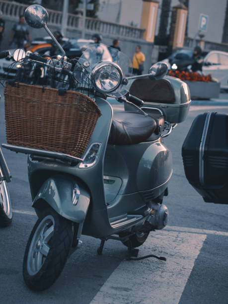 istock Classic Vespa type scooter with a wicker basket on the handlebars, a very romantic and adorable image that reminds us of a not too distant past where the roads and paths were full of these vehicles. 1406679370