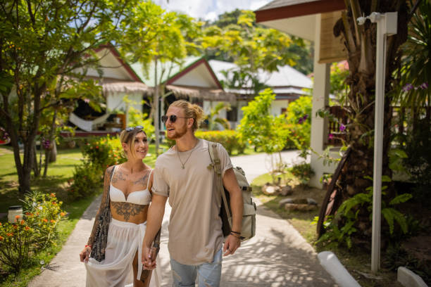 istock Young Caucasian couple holding hands, while walking through tourist resort 1406680037