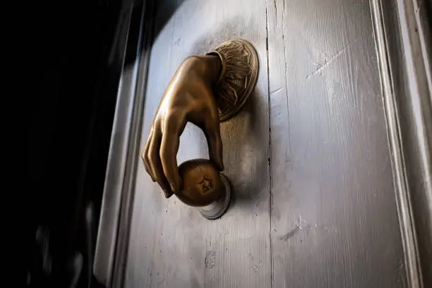 Bronze ancient knocker against old wooden door