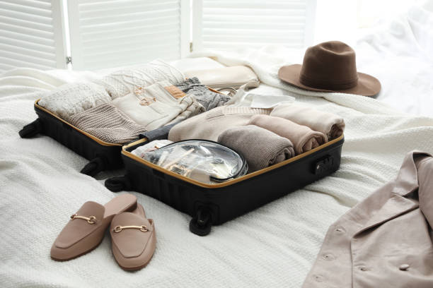 istock Open suitcase with folded clothes, shoes and accessories on bed 1406681847