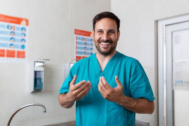 石鹸で手を洗う医師。男性外科医は手術の準備をしています。彼は手術室で制服を着ている。 - scrubs surgeon standing uniform ストックフォトと画像