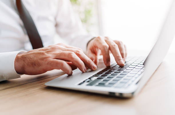 istock Businessman using laptop computer, hands typing keyboard at office desk 1406685099