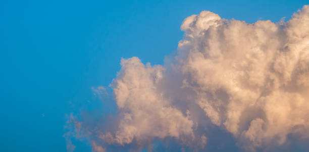istock White cumulus clouds reflect the evening sunlight on a blue background, more than the space of an image, Natural abstract. 1406688281