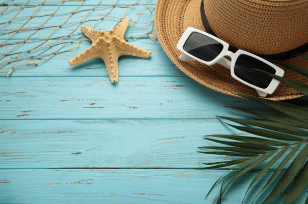 istock Summer vacation flat lay. Palm leaves, straw hat and sunglasses on blue background. Copy space 1406688407