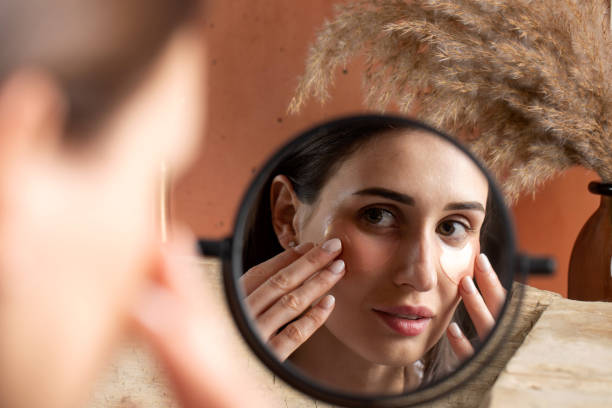 istock Mirror reflection of woman applying under-eye patch at dressing table closeup 1406690406