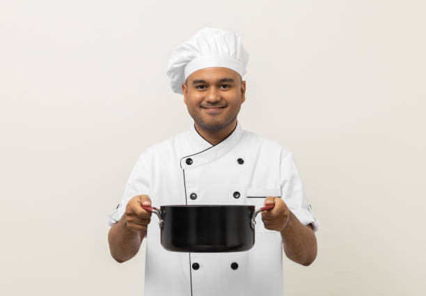 istock Young asian man chef in uniform holding soup pot utensils cooking in the kitchen various gesture action on isolated background. Indian man Occupation chef restaurant and hotel. 1406690773